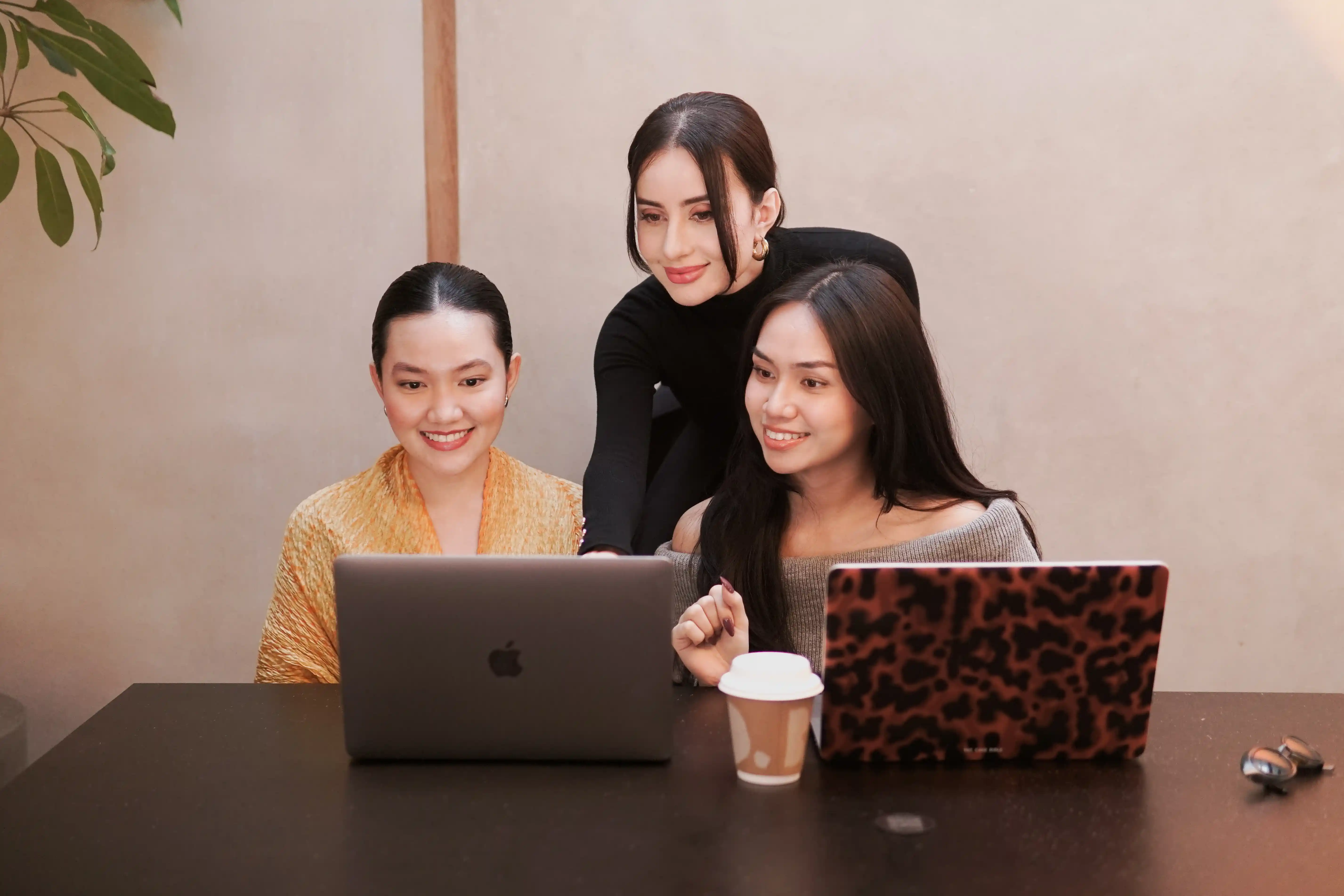 Three KATA team members holding laptops, close angle during the brand content shoot